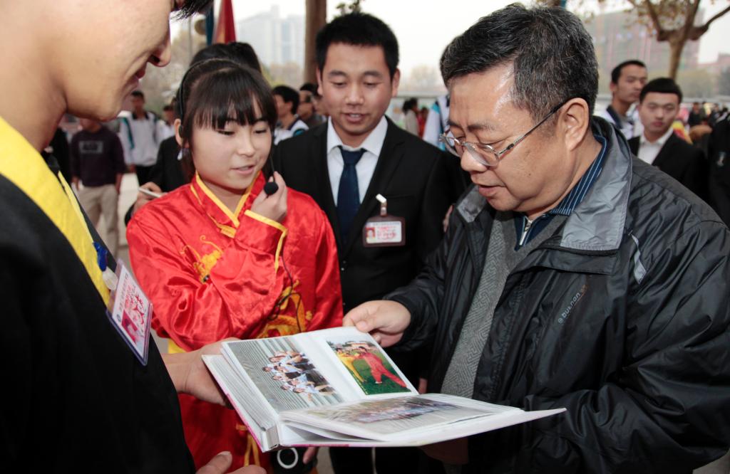 党委书记邓志辉仔细翻看武术协会活动记录影集